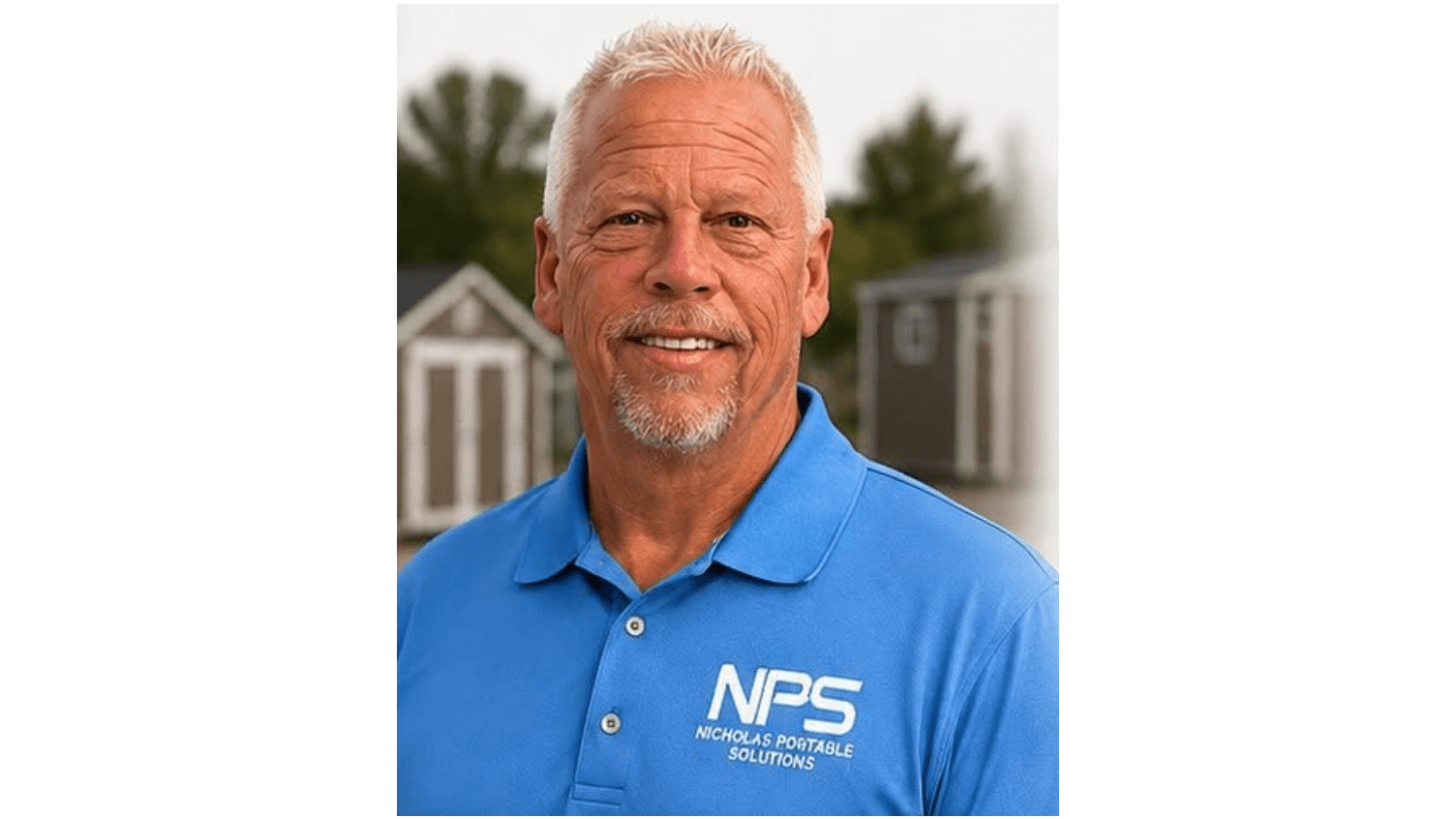 Smiling man wearing a blue Nicholas Portable Solutions polo shirt in front of sheds.